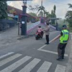 Pelayanan Masyarakat Polsek Sukadana Polres Ciamis Bantu Anak Menyebrang di Area Sekolah