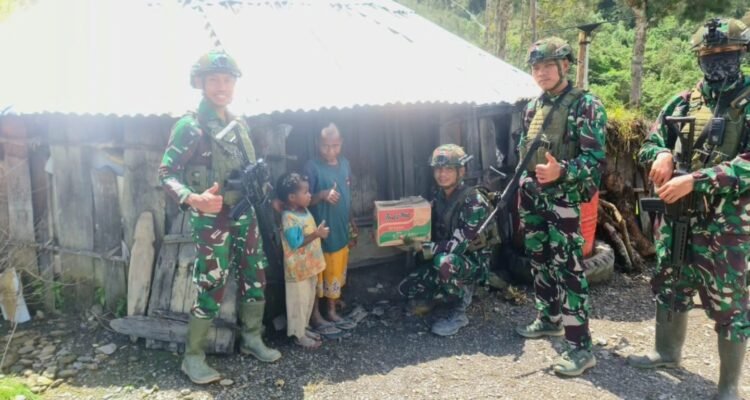 Senyum Bahagia Anak Papua,  Prajurit TK Pintu Jawa Satgas Yonif 323 Berbagi Makanan dan Permen Dalam Rangka HUT Ke-79 TNI