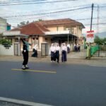Pelayanan Masyarakat Polsek Cipaku Polres Ciamis Bantu Anak Sekolah Menyebrang di Jalur Padat