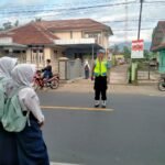Pelayanan Masyarakat Polsek Cipaku Polres Ciamis Bantu Anak Sekolah Menyebrang di Jalur Padat