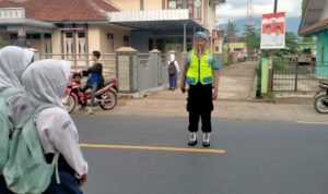 Pelayanan Masyarakat Polsek Cipaku Polres Ciamis Bantu Anak Sekolah Menyebrang di Jalur Padat