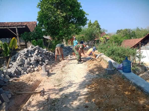 Tumbuhkan Semangat Gotong Royong Babinsa Bantu Pasang Paving Block