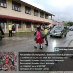 Babinsa Koramil 01/Gunungsitoli Bersama Personel Lantas dan Provoost Bantu Anak Sekolah Menyeberang Jalan