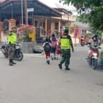 Babinsa Koramil 12/Telukdalam Bantu Anak Sekolah Menyeberang di Jalan Raya