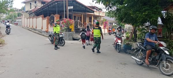 Babinsa Koramil 12/Telukdalam Bantu Anak Sekolah Menyeberang di Jalan Raya